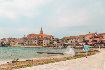 Obraz premium woman walking by umag city quay at stormy weather. copy space
