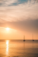 Naklejka na ściany i meble sunset over sea bay with yachts on background