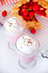 strawberry smoothie milk shake cocktail with whipped cream.