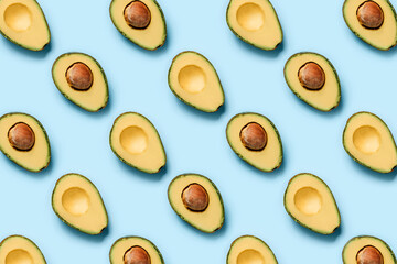 Pattern of halves of avocado on a blue background.