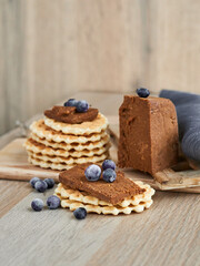 Viennese waffles with Norwegian brunost cheese and blueberries. Breakfast with Traditional Scandinavian brown cheese