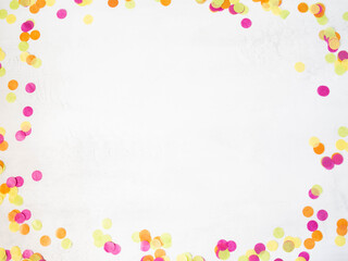 Colorful paper confetti scattered on a white background. Top view