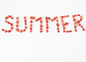 Word summer created from fresh ripe wild strawberries on a white background. Top view. copy space