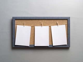 Three empty photos on clothespins in a canvas frame on a gray background. Layout. Empty space. Stylized stock photos.