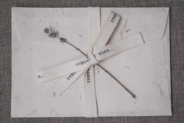 Vintage envelope with beige ribbon. Eco-friendly handmade paper. Sprig of lavender.