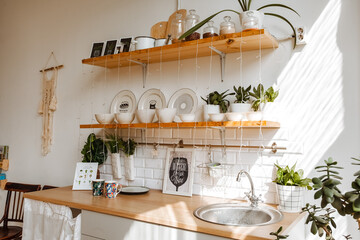the sun's rays fall on the kitchen set, glare from the sun on the dishes, the interior of the dining area, stylish youth design for bright rooms
