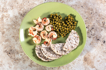 prawns on a plate with green peas and bread rolls. Homemade healthy food. Delicacy from Asia.