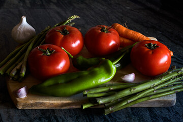 Vegetables still life with tomatoes, peppers, carrots, asparagus and garlics