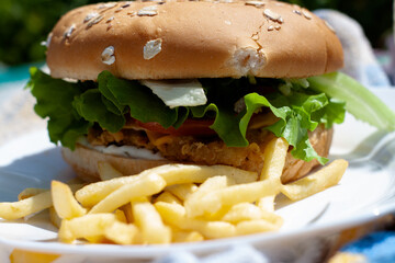 hamburger with lettuce on a plate with French fries