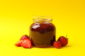 Delicious strawberry jam on yellow background, space for text