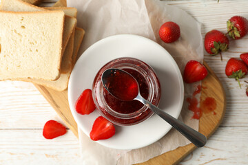 Composition with strawberry jam on white wooden background, top view