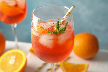 Composition with aperol spritz cocktail against blue background