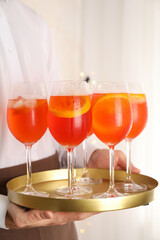 Waiter holding tray with aperol spritz cocktail. Summer drink