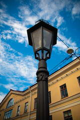 Fototapeta na wymiar old street lamp on blue sky with clouds background