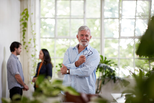 Professional businessman standing, thinking in an open plan office studio