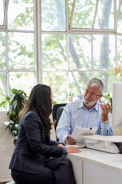 Mature aged male office worker meeting with a woman in a creative warehouse space