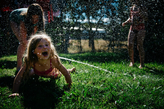 Girls Playing With Water In Garden