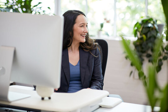 Professional business woman sitting at a computer in an office studio