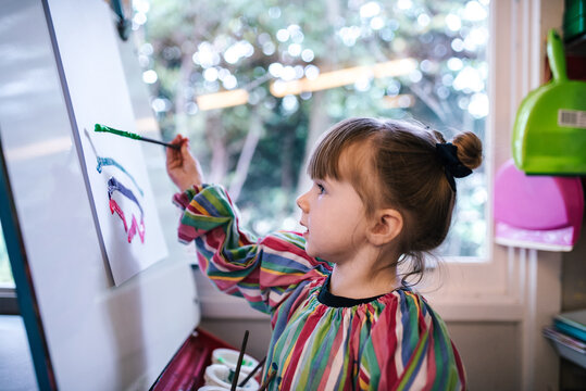 Preschool girl painting a picture