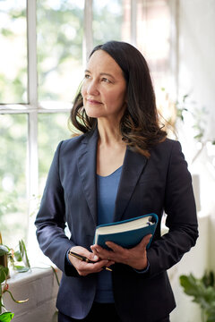 Business woman standing in studio holding a folder