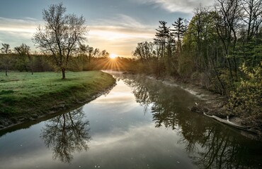 A sunrise over the river during springtime