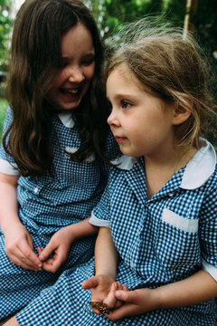 Girls in school uniform sitting outdoors