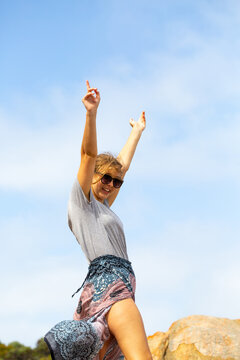 Young woman with arms in the air in exaultation