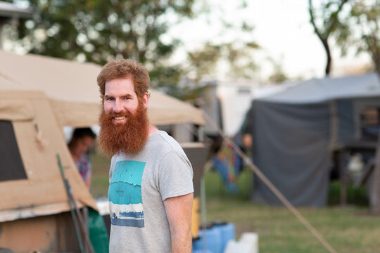 Bearded man near camper trailer in campground