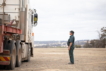 portly fellow looking up to talk to a truck driver
