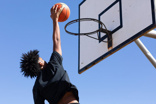 Basketball hoop with young guy about to slam a goal