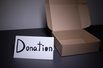 donation sign handwritten with black letters near a box. donation concept. Context of The...