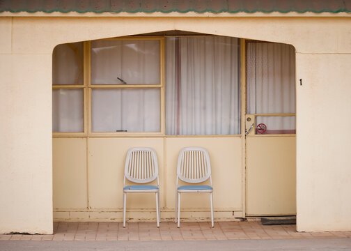 Chairs outside a pale yellow motel room on the Nullarbor