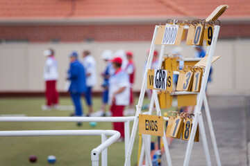 Scoreboard and bowlers at a lawn bowls club