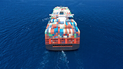 Aerial drone photo of fully loaded truck size container ship cruising in open ocean deep blue sea