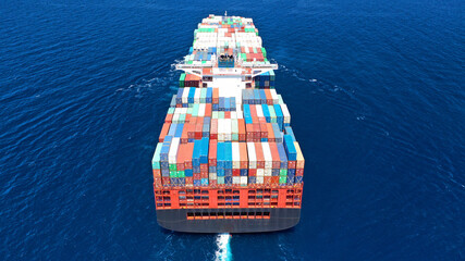 Aerial drone photo of fully loaded truck size container ship cruising in open ocean deep blue sea