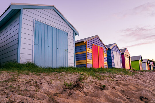 Ground level view of a row of colorful timber bathing boxes