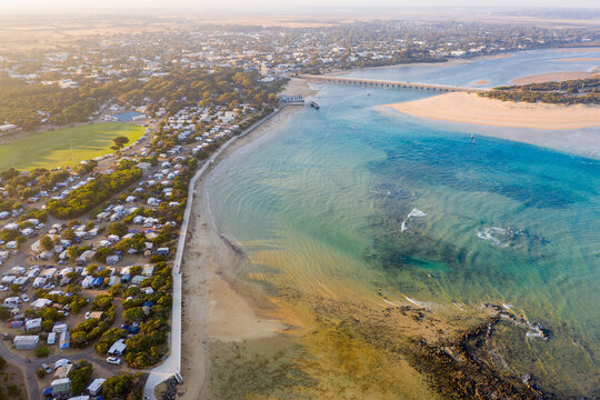 Aerial view of a coastal town and caravan park near a river mouth