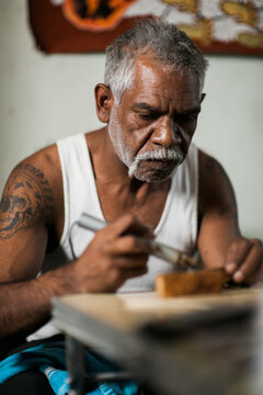 Man carving on wood with wood burner