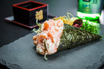 Temaki Sushi. Traditional Japanese cuisine, premium salmon Temaki with cream cheese decorated in an elegant setting.
