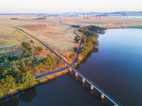 Aerial view of a railway bridge crossing a lake in early morning sunshine