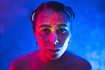 Body art on woman glowing in ultraviolet light. Art and sensuality concept with neon lighting.