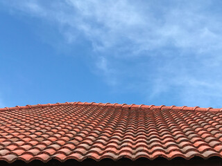Fototapeta premium Red burgundy roof tiles on blue sky.