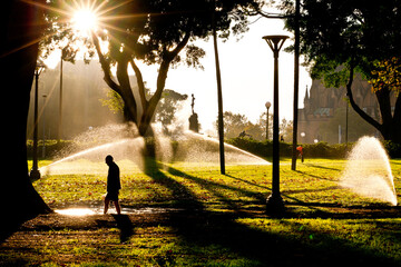 Silhouette of a man walking through hyde park in the early morning