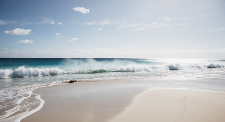 Waves on empty beach in morning light