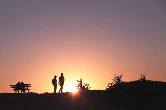 Silhouettes walking at sunset