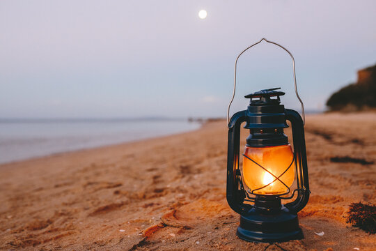 Close up of kerosene lamp on beach at dusk