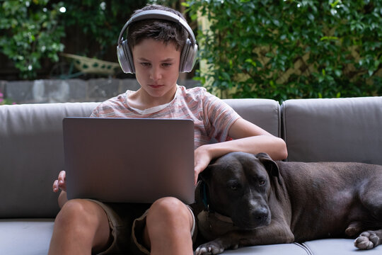 Young boy using laptop outside