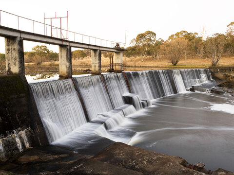 Water flowing over a curved concrete dam wall