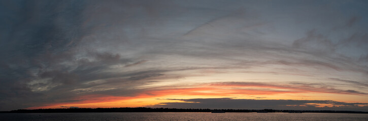 Colorful Sunny sunset over a navigable calm river. Panorama