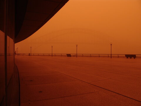 View of boardwalk and Sydney Harbor Bridge in red dust storm